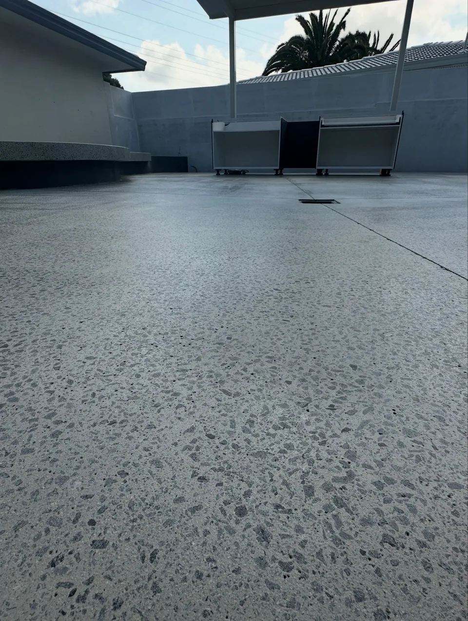 Close view of a honed and sealed concrete courtyard with exposed aggregate