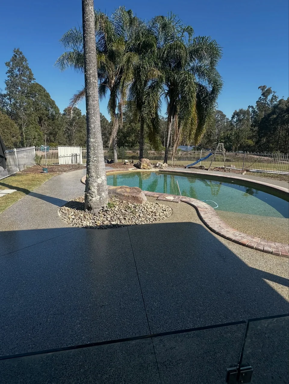 Restored honed concrete entertaining area beside a swimming pool